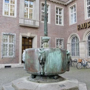 Carnival fountain Fastnachtsbrunnen vor dem historischen Gebäude in Köln, mit bogenförmigen Figuren und Brunnenbecken.Carnival fountain in front of the historic building in Cologne, with arched figures and fountain basin.