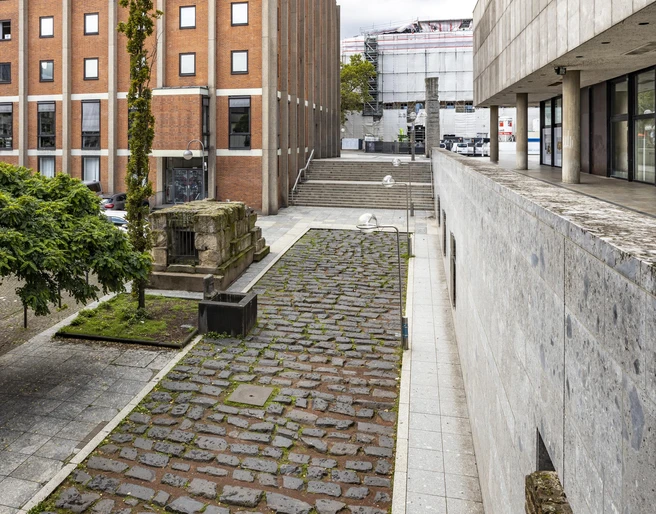 Roman harbor road Römische Hafenstraße in Köln, gepflasterter Weg zwischen modernen GebäudenRoman harbor road in Cologne, paved path between modern buildings