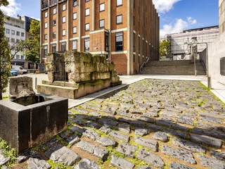 Roman harbor road Römische Hafenstraße in Köln mit altem Mauerwerk, gepflastertem Weg und modernem Gebäude im Hintergrund.Roman harbor road in Cologne with old masonry, paved path and modern building in the background.