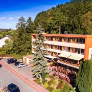 Hotel Waldcafe Jäger Bad Driburg_Komplettaufnahme_Avenarius Wohlfühlhotels_2500.jpg Hotel Waldcafe Jäger Bad Driburg umgeben von Bäumen mit Terrasse und angrenzendem Parkplatz
