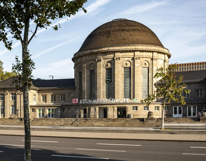 KoelnMesse Deutz station Historischer Empfangsbereich des Bahnhofs Köln Messe/Deutz mit markantem Kuppeldach unter blauem Himmel.Historic reception area of Cologne Messe/Deutz station with striking domed roof under a blue sky.