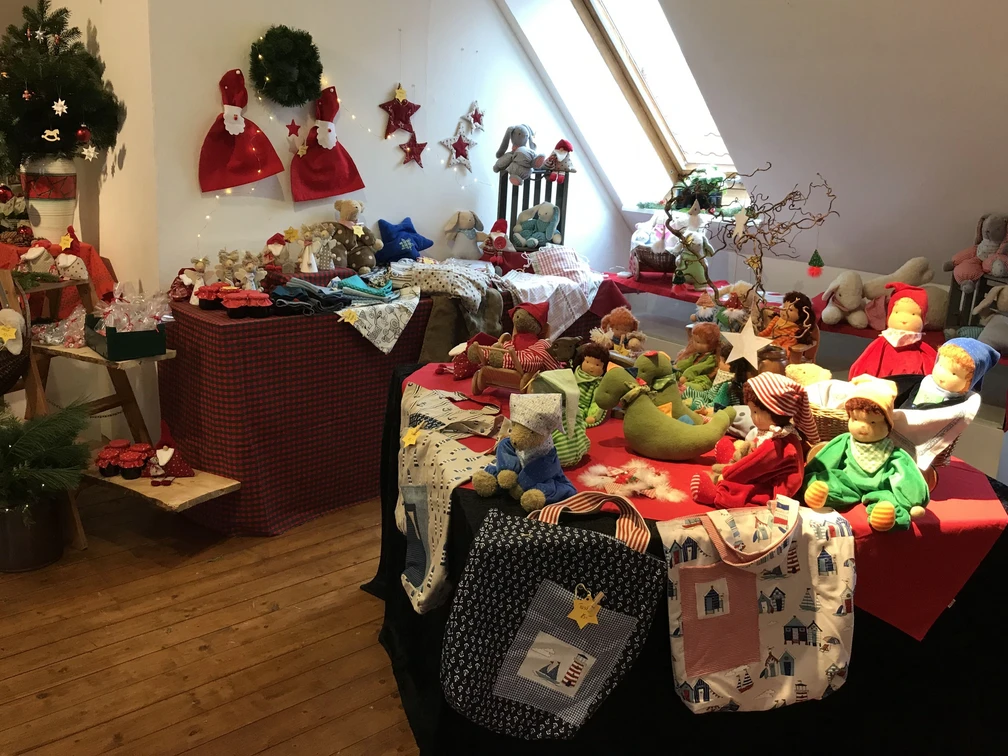 Nostalgische Weihnacht Weihnachtsdekoration und handgefertigte Puppen auf einem Holzboden in einem hellen Raum mit Dachfenster.