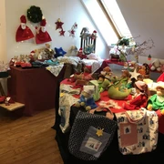 Nostalgische Weihnacht Weihnachtsdekoration und handgefertigte Puppen auf einem Holzboden in einem hellen Raum mit Dachfenster.