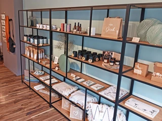 G-Werk_Deko.jpg Langes Regal mit hübsch dekorierter Ware: Textilien, Kerzen und vieles mehr
