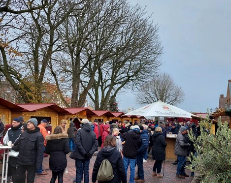 Weihnachtsmarkt Greetsiel 2022 Zu sehen sind ein paar Weihnachtsbuden und Menschen von weitem.