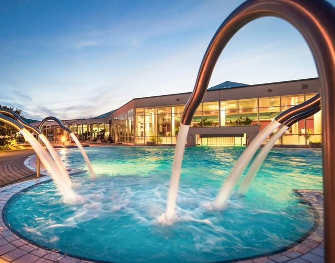 Badelandschaft des HEIDE SPA Bad Düben am Abend - Wellness in Leipzig und Region Der Außenbereich des HEIDE SPA in Bad Düben mit Pool wird zur Abenddämmerung beleuchtet, Wellness, Ausflug, Familie, Freizeit