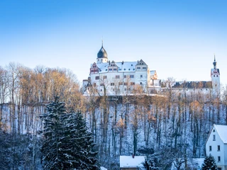 Schloss Rochsburg im Winter - Schlösser der Leipzig Region Blick auf das verschneite Schloss Rochsburg auf einem Felssporn, umgeben von kahlen Bäumen zur untergehenden Sonne, Ausflugsziel
