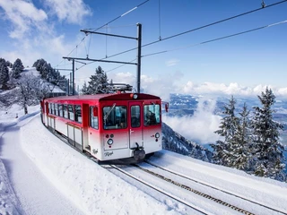 Vitznau - Rigi cogwheel railway in winter Die Zahnradbahn fährt durch die verschneite LandschaftThe cog railway travels through the snow-covered landscapeLe train à crémaillère traverse le paysage enneigé