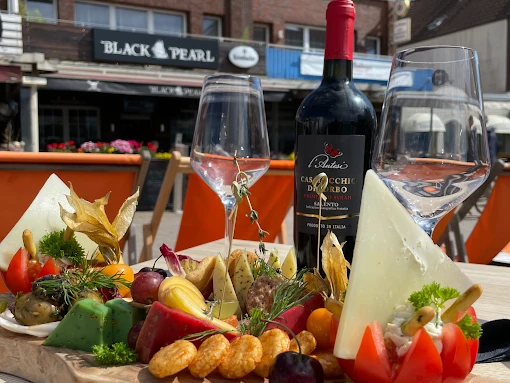 Vielzahl bunter Käsesorten mit frischen Früchten und Snacks vor der Black Pearl in Borkum.A variety of colorful cheese types with fresh fruits and snacks in front of the Black Pearl in Borkum.