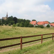 Kloster Loccum Kloster Loccum mit rotem Ziegeldach und Kirchturm inmitten grüner Wiesen und bewaldeter Hügel.