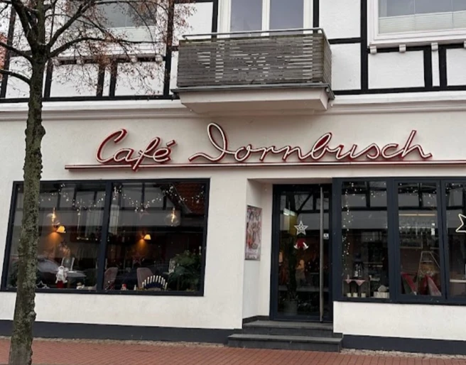 Fachwerkgebäude mit Café Dornbusch, breite Fensterfront, Leuchtreklame und großer Eistüte außen.