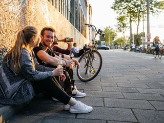 Westwerk Karl-Heine-Straße - Szeneviertel im Leipziger Westen Drei junge Menschen sitzen entspannt mit Getränken in der Hand am Westwerk auf der Karl-Heine-Straße im Leipziger Szeneviertel Plagwitz