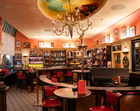Die großzügige Bar im Mephisto serviert kreative Drinks – Gastronomien in Leipzig Der gemütliche Innenbereich der Mephisto Bar mit vielen roten Sitzmöbeln lädt zum Verweilen ein, Gastronomie