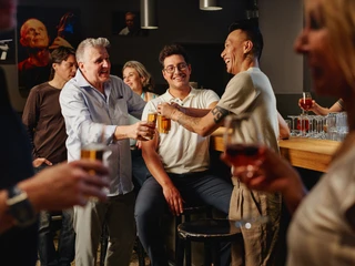 Stadtgarten In einem gemütlichen Barambiente wird ein lebhaftes Gespräch unter Freund*innen geführt.A lively conversation between friends takes place in a cozy bar atmosphere.