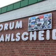 Forum Wahlscheid <p>Backsteinfassade mit der Aufschrift "FORUM WAHLSCHEID" und Fotocollage oberhalb der Buchstaben.</p>