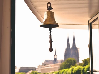 Glocke vor dem Kölner Dom Schiffsglocke der MS RheinLand, im Hintergrund der Kölner DomShip's bell of the MS RheinLand, Cologne Cathedral in the background