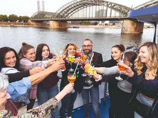 Feierstimmung an Bord Feiernde Menschen mit Getränken auf dem Deck eines SchiffsPeople celebrating with drinks on the deck of a ship