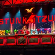 Stunksitzung Eine lebendig dekorierte Bühne mit kostümierten Künstlern, die Teil der Kölner Stunksitzung sind.A lively decorated stage with costumed artists who are part of the Cologne Stunksitzung.