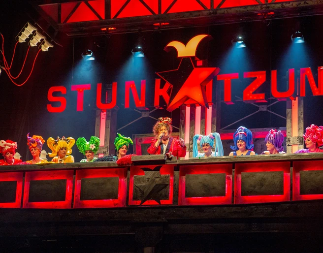 Stunksitzung Eine lebendig dekorierte Bühne mit kostümierten Künstlern, die Teil der Kölner Stunksitzung sind.A lively decorated stage with costumed artists who are part of the Cologne Stunksitzung.