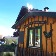Boaneggers Freilandeier Farchant braunes Holzhütterl mit Fenster und der Aufschrift Boanegger`s Eierhütte