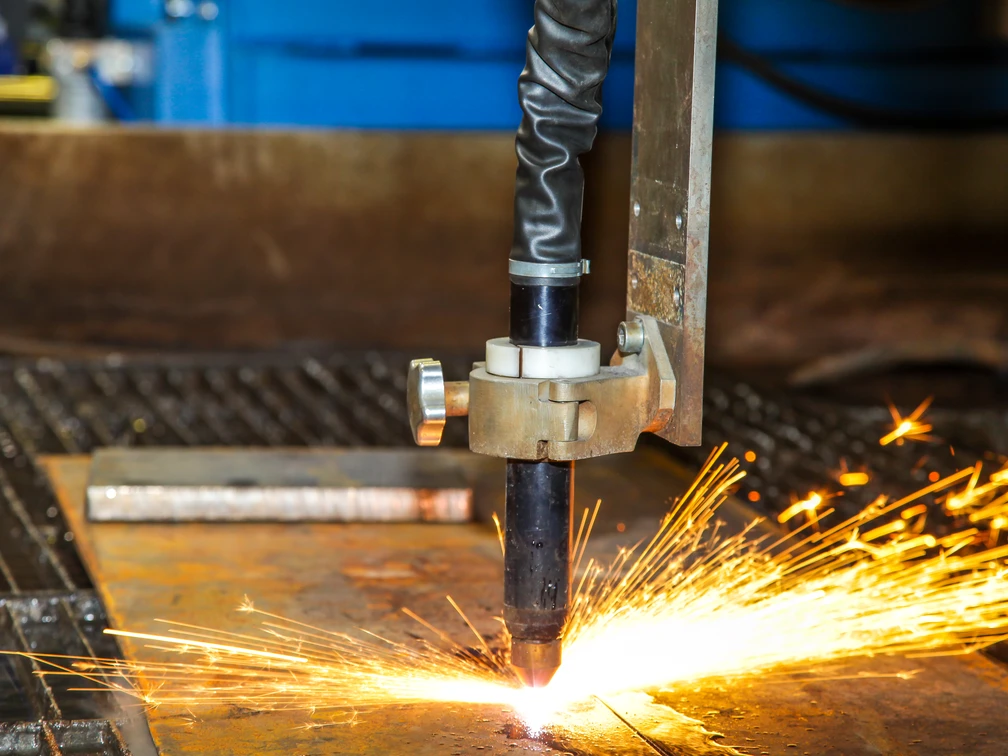 Handwerk Ein Schneidbrenner durchtrennt Metall, während Funken sprühen. Einblick in handwerkliche Präzision.