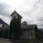 Evangelische Markuskirche Farchant Aussenansicht der Kirche mit Kreuz und mit von Efeu umranktem Turm
