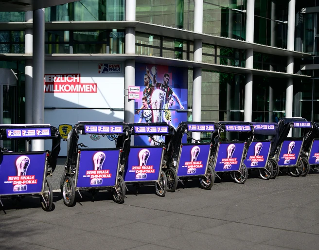 Rikolonia_Event Handball I.jpeg Reihe von Werbbeleuchtungen für das REWE-Finale der DFB-Pokal-Saison vor einer modernen Halle.</p>Series of advertising lights for the REWE final of the DFB Cup season in front of a modern hall.</p> <p