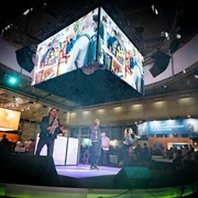 Frauenthal-Expo-Wien-PLUS-Messeband-Entertainment-DJplus-04.jpg Musiker auf einer Messebühne, große Bildschirme zeigen lebhafte Szenen, umgeben von Publikum.</p>Musicians on an exhibition stage, large screens show lively scenes, surrounded by an audience.</p> <p