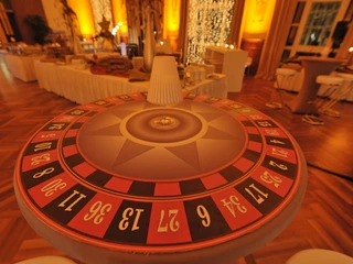Casino Vinophil. Zubehör Roulettetisch in festlich dekoriertem Raum mit gedämpftem, warmem Licht.Roulette table in a festively decorated room with subdued, warm lighting.