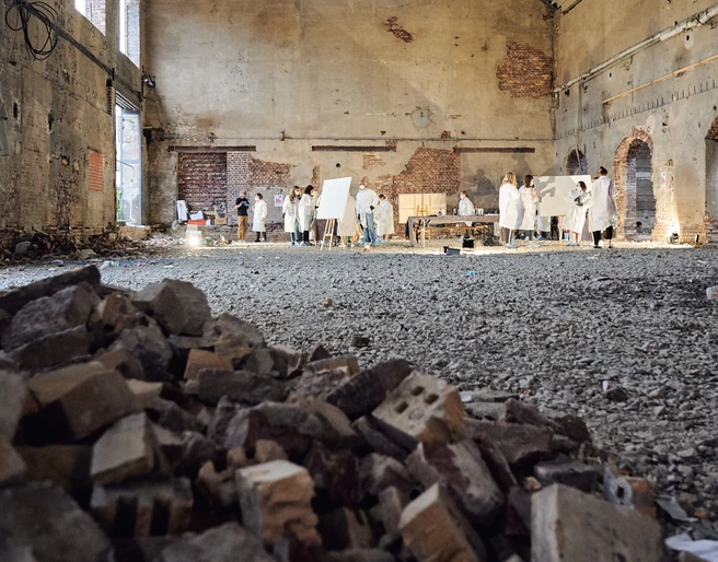 Cologne Graffiti. Urbane Location Künstler in weißer Kleidung malen in einer großen, verlassenen Industriehalle mit Ziegelhaufen.</p>Artists in white clothing paint in a large, abandoned industrial hall with piles of bricks.</p> <p