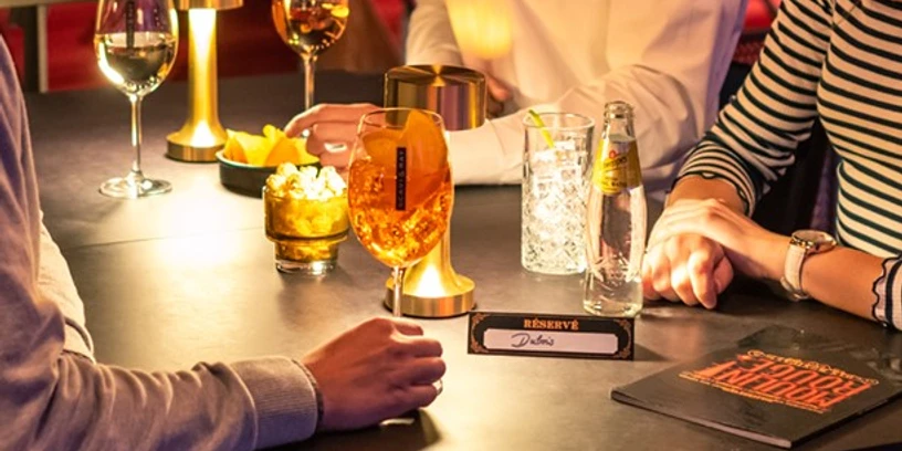 MDK_Gruppe_1 Eine gemütliche Bar, Menschen bei Getränken, gedimmtes Licht, atmosphärisch und gesellig.A cozy bar, people enjoying drinks, dimmed lights, atmospheric and sociable.