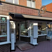 Gebäude aus roten Backsteinen mit weißen Vitrinen im Eingang.Building made of red bricks with white showcases at the entrance.