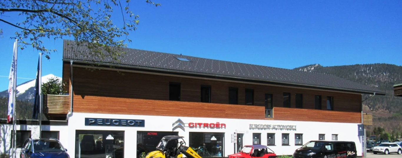 Auto Burgdorf Farchant Haus mit Büro und Ausstellungsraum, davor stehen 3 Autos und ein kleiner Bagger