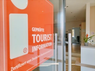 Bispingen-Touristik.jpg Ein offener Eingangsbereich mit einem Schild "Geprüfte Tourist Information" und modernem Interieur.