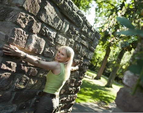 hx-stadtentdecken-andreashub (4).jpg Frau mit ausgebreiteten Armen an der Stadtmauer