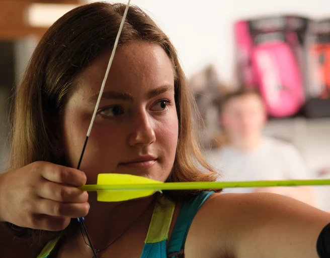 Konzentration aufs Ziel Nahaufnahme einer Bogenschützin, die den Bogen spannt