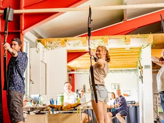 Für jedes Alter geeignet 3 Bogenschützen haben einen Pfeil in den Bogen gespannt und sind bereit zum schießen.