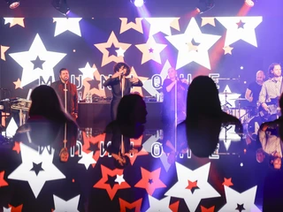 4_Events.jpg Live-Band spielt auf Bühne; Leuchtsterne im Hintergrund; Publikum in vorderem Bereich.Live band plays on stage; illuminated stars in the background; audience in the front area.
