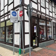 Dombrowsky.jpg Fachwerkgeschäft an einer Straßenecke, Schilder weisen auf Fahrradstraße und Einfahrtverbot hin.