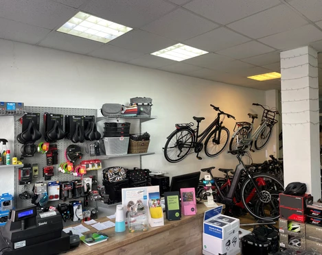 Rademachers Radshop Rademachers Radshop: Innenansicht mit Fahrrädern, Zubehör an der Wand und Empfangstheke.