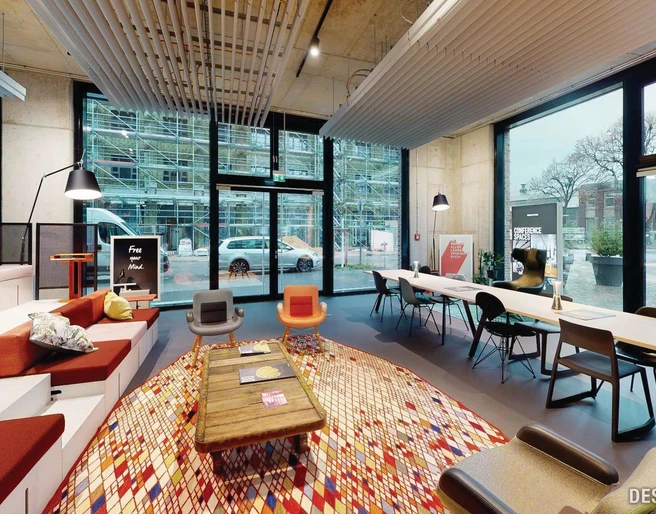 Lounge Das Bild zeigt ein modernes, einladendes Büro mit großen Fenstern, stilvollen Sitzbereichen und Tischen.The picture shows a modern, inviting office with large windows, stylish seating areas and tables.