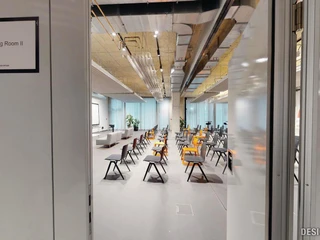 Training Room II Ein moderner Seminarraum mit Reihen aus orange und schwarz gepolsterten Stühlen in einem Bürogebäude.</p>A modern seminar room with rows of orange and black upholstered chairs in an office building.</p> <p