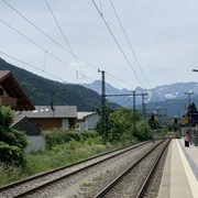 IMG_7708.jpg Bahngleise mit Oberleitungen, linker Hand Häuser und in weiter Ferne das Wettersteinmassiv