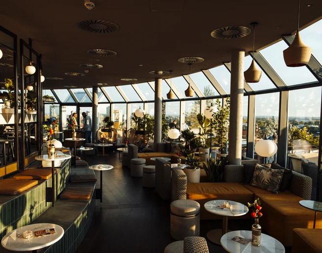 Bar Botanik Innenbereich.jpg Moderne Lounge-Bar mit Panoramafenstern, stilvollen Sitzgelegenheiten und Pflanzen.</p>Modern lounge bar with panoramic windows, stylish seating and plants.</p> <p