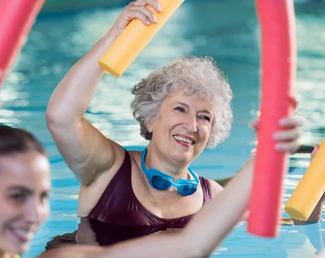 Koppke Greetsiel Dame im Wasser mit Poolnudel, aktiv bei der Wassergymnastik