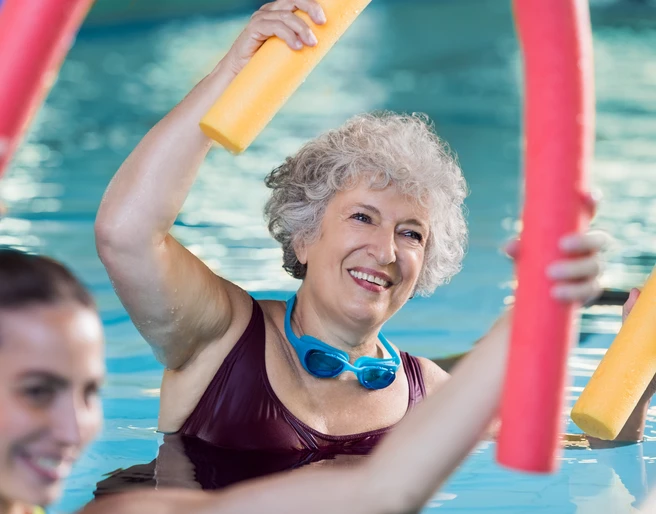 Koppke Greetsiel Dame im Wasser mit Poolnudel, aktiv bei der Wassergymnastik
