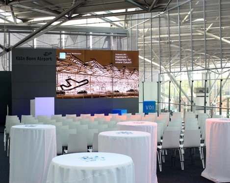 Sitzreihen und Videowall.JPG Moderner Konferenzraum am Köln Bonn Airport mit Stuhlreihen und informativem Bildschirm.</p>Modern conference room at Cologne Bonn Airport with rows of chairs and informative screen.</p> <p