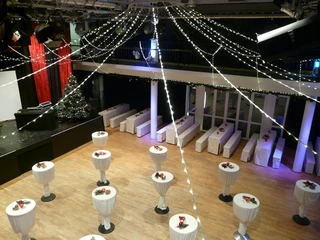 Großer Saal im BHK Rundtische mit weißen Tischdecken in festlich beleuchtetem Bankettsaal, Weihnachtsschmuck auf jedem Tisch.Round tables with white tablecloths in a festively lit banquet hall, Christmas decorations on every table.