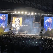 Dagamba Open-Air-Konzert bei Nacht mit beleuchteter Bühne, großer Menschenmenge und Videobildschirm.</p>Open-air concert at night with illuminated stage, large crowd and video screen.</p> <p
