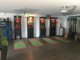 Turnier Dart-Gerät 01 Elektronische Dartscheiben in einem Raum mit Holzboden und Dekoration.Electronic dartboards in a room with wooden floor and decoration.